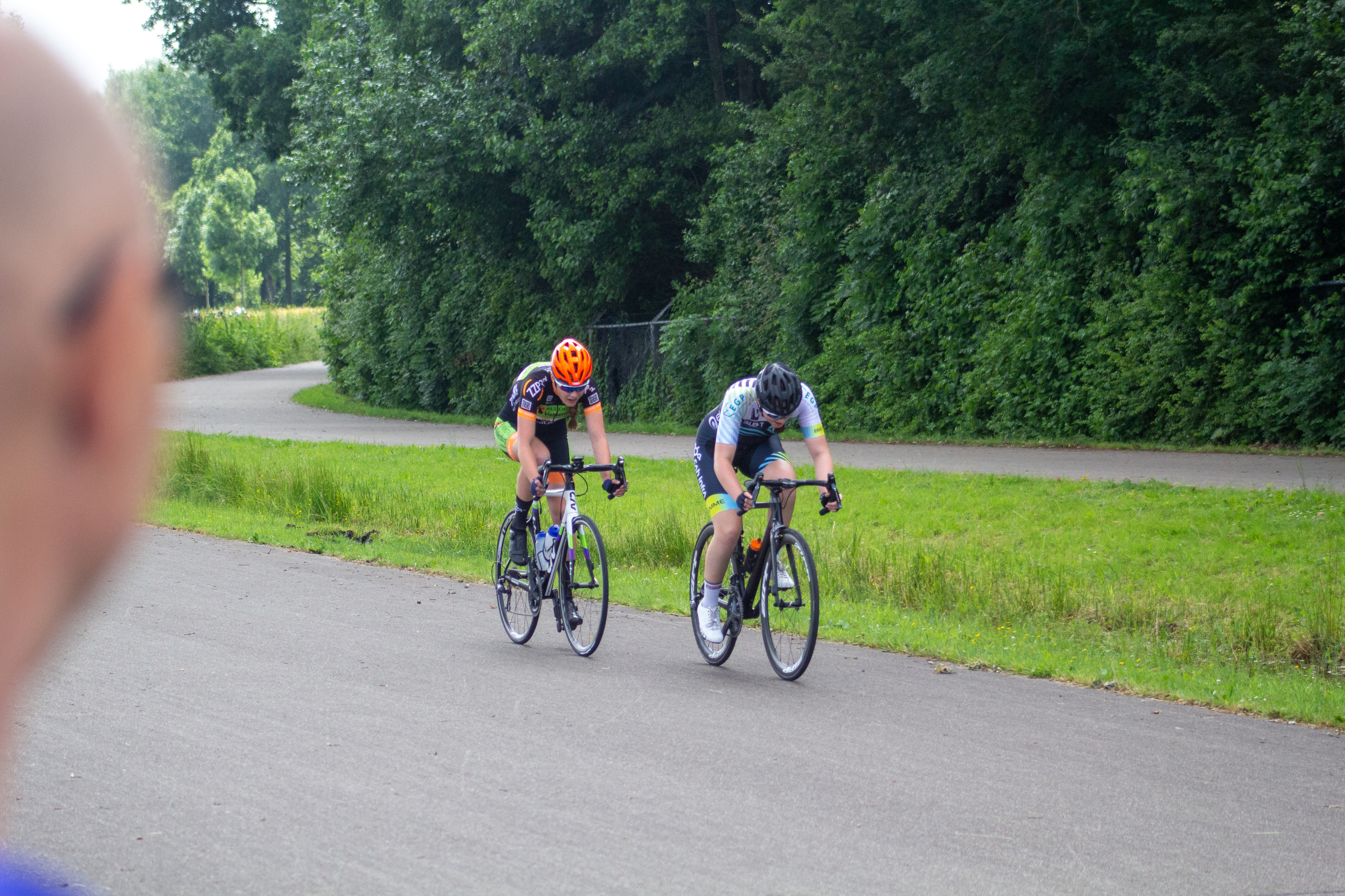 Two cyclists are racing down a road during the Dames ronde van Deventer race.