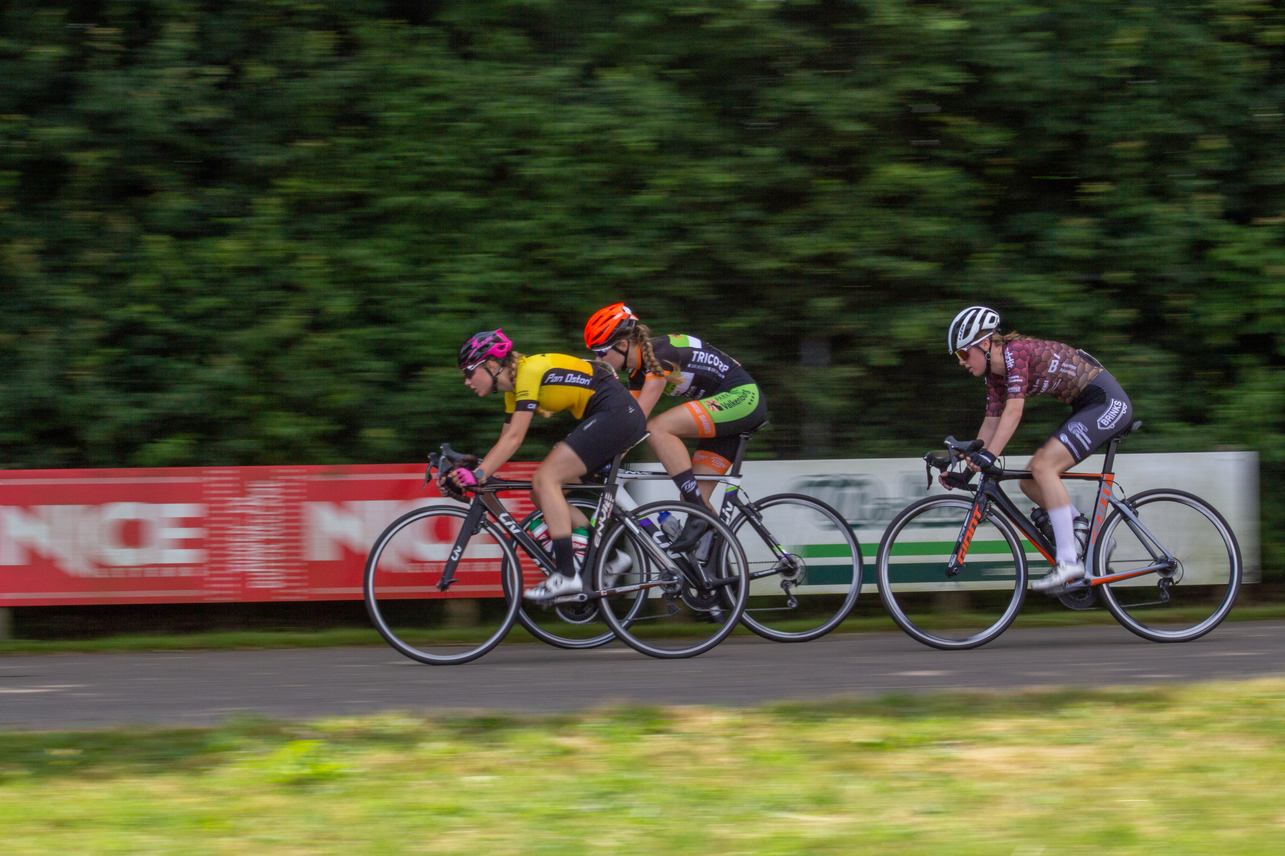 A group of cyclists riding on a road during the Dames Rond van Deventer.