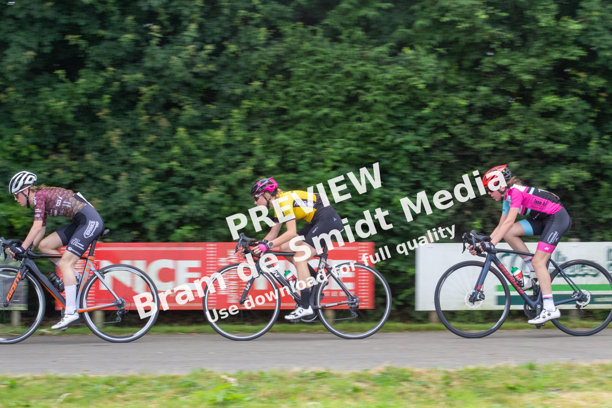 A group of cyclists ride on a race track for the Dames Ronde Van Deventer.