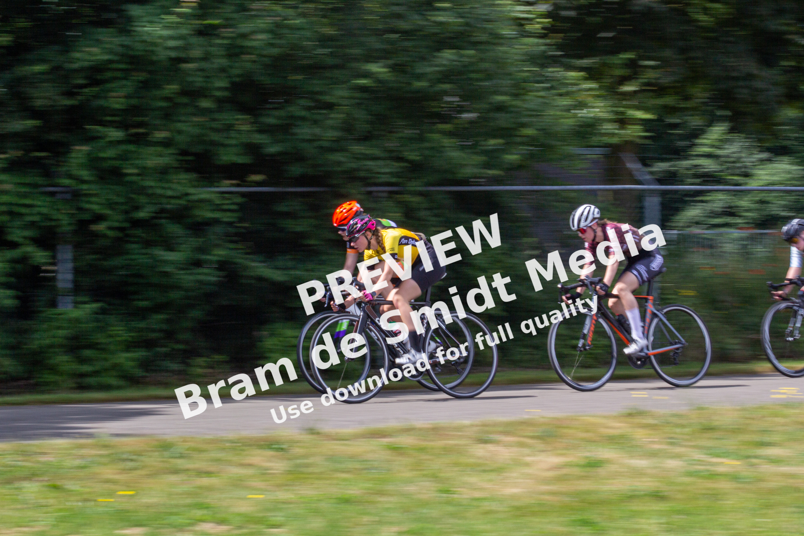 Three cyclists racing on a track during Dames ronde van Deventer.