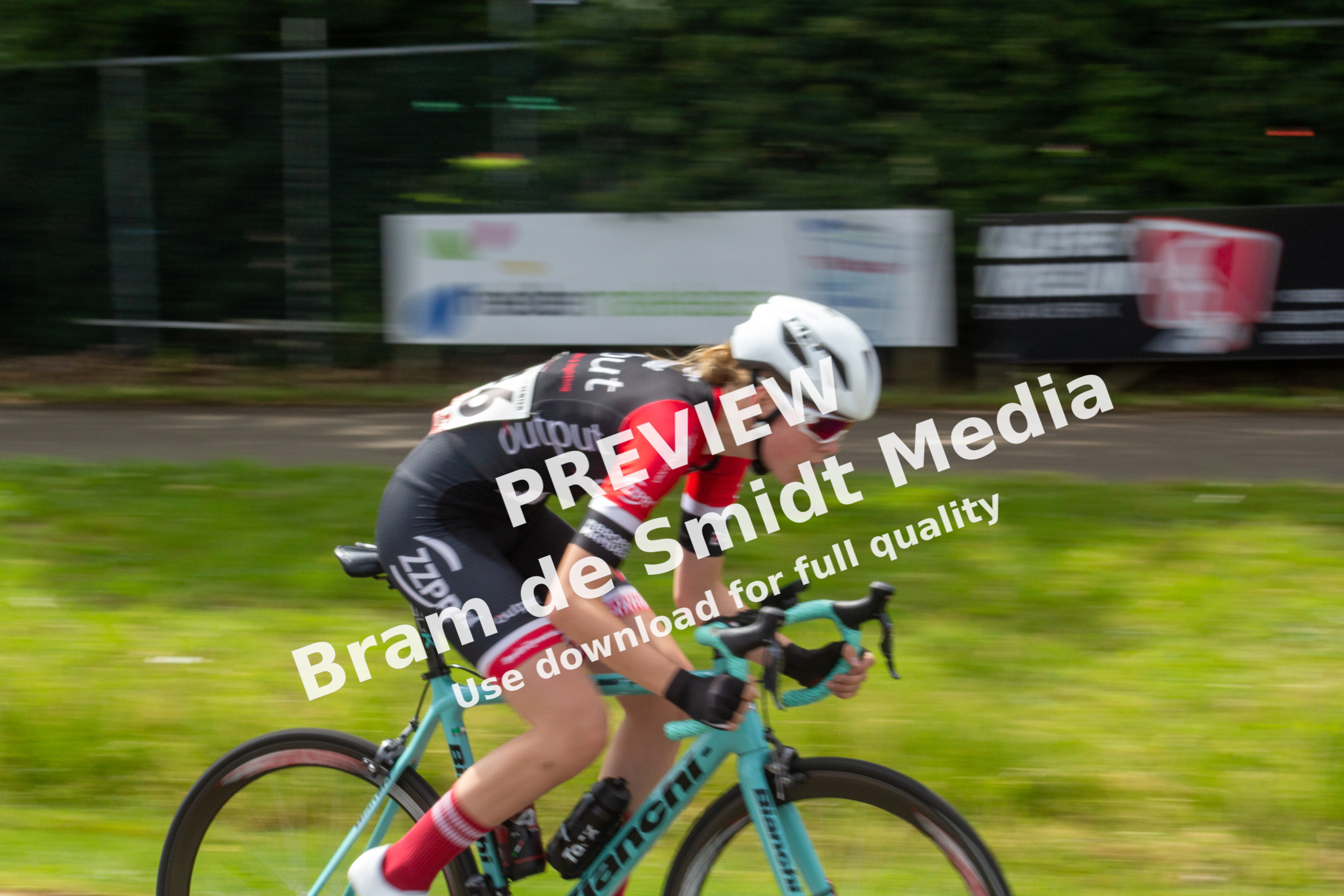 A female cyclist racing in a race sponsored by the company Wielrennen.