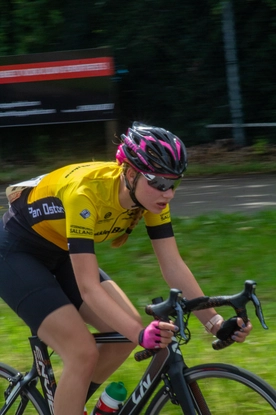 A young girl is racing on a bike in the Dames ronde van Deventer, a cycling event for women.