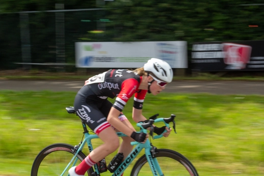 A female cyclist racing in a race sponsored by the company Wielrennen.