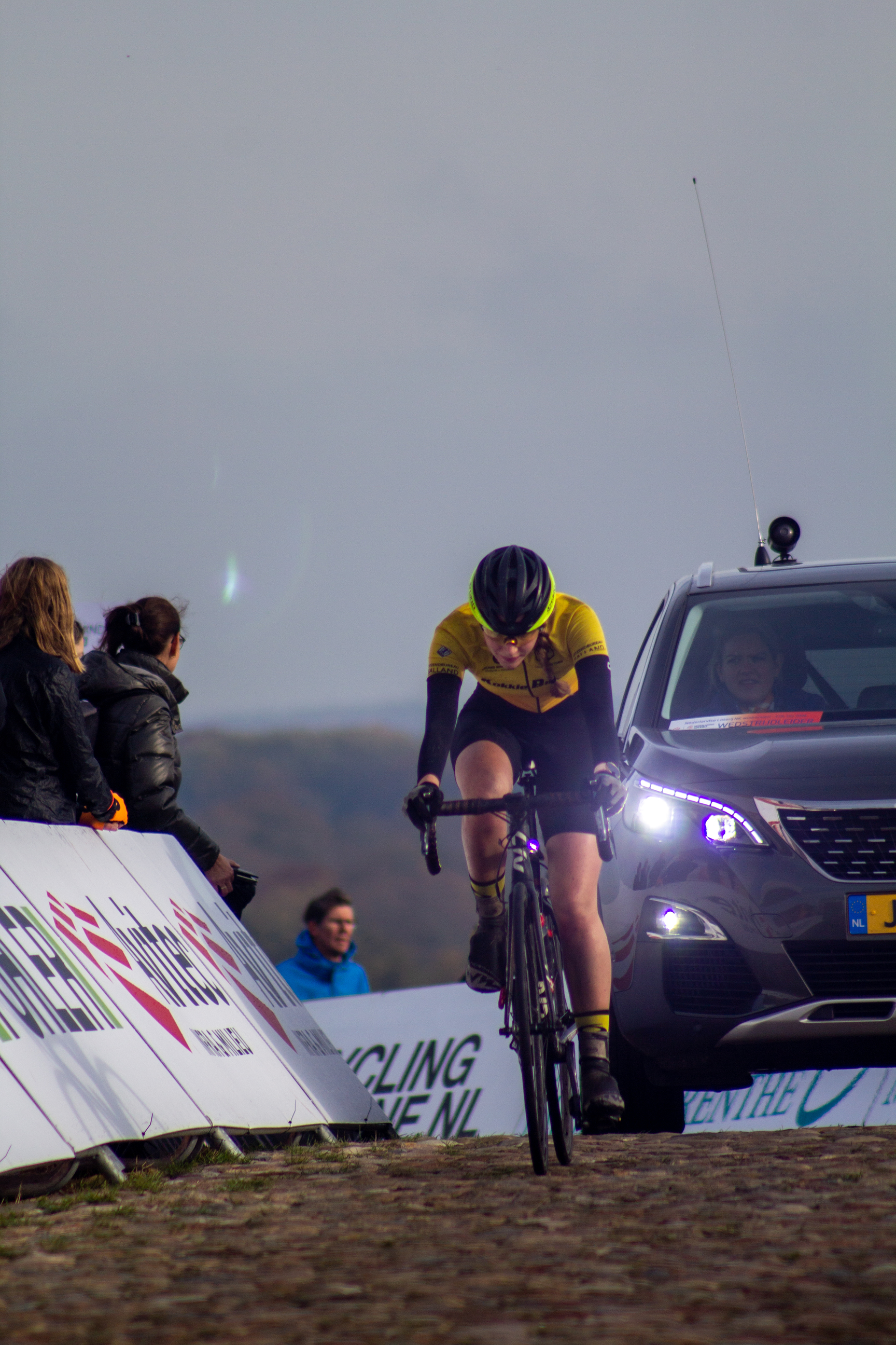 A cyclist participating in the NK Nieuweling Dames race, number 7.