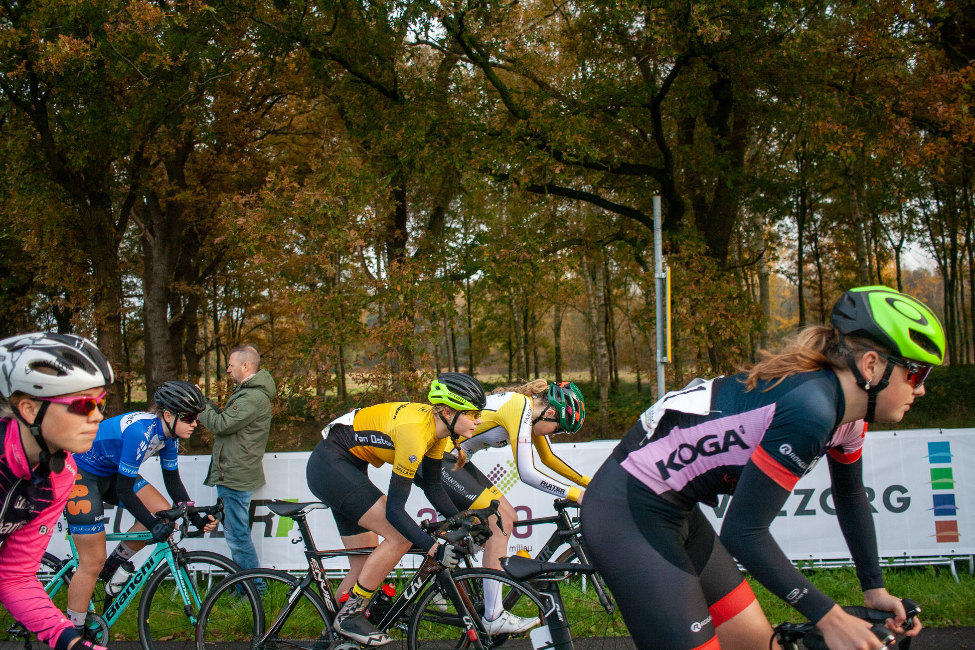 Five female cyclists in a race, one of them wearing the number 11.