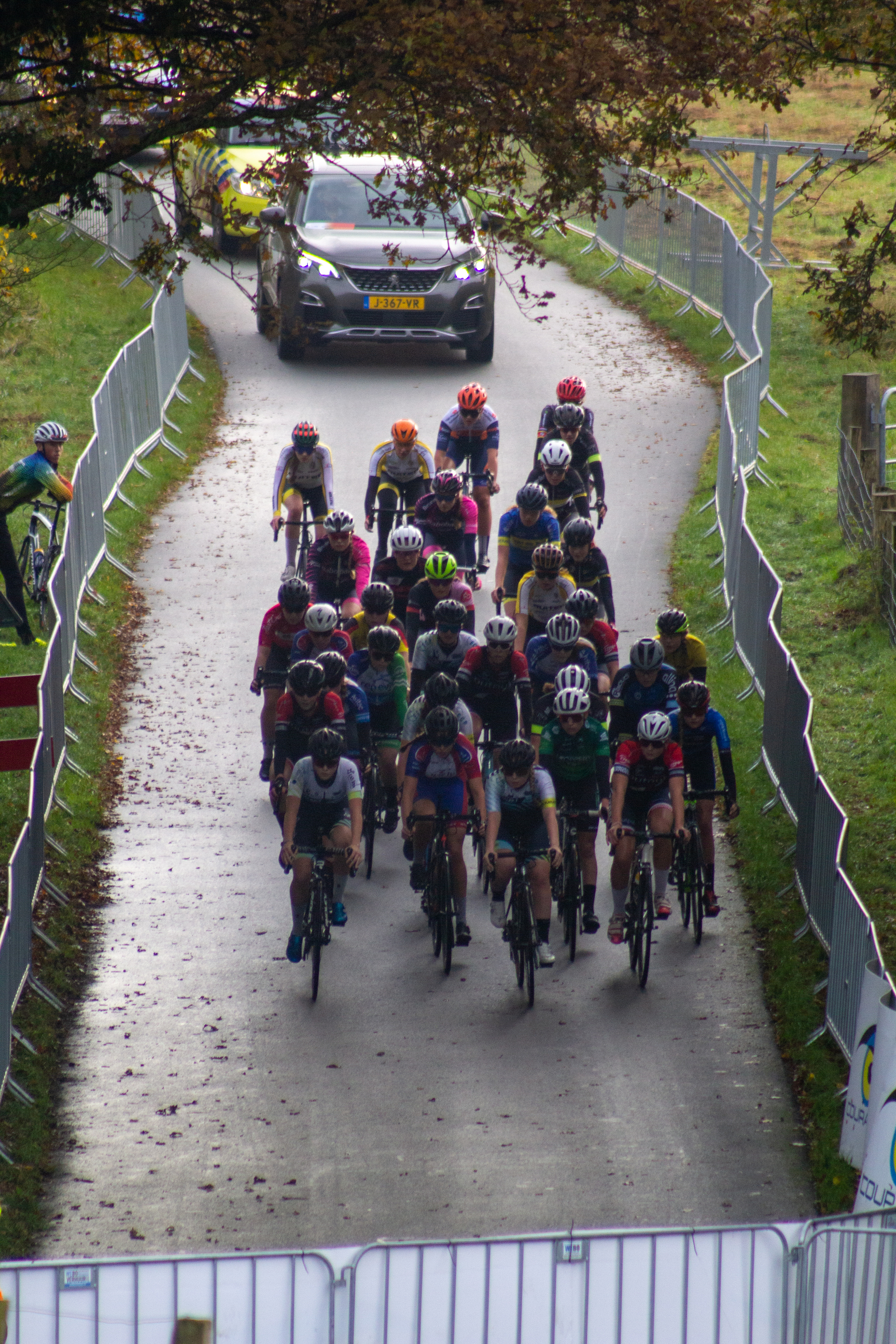 A group of bicyclists race down a street in NK Nieuweling dames.