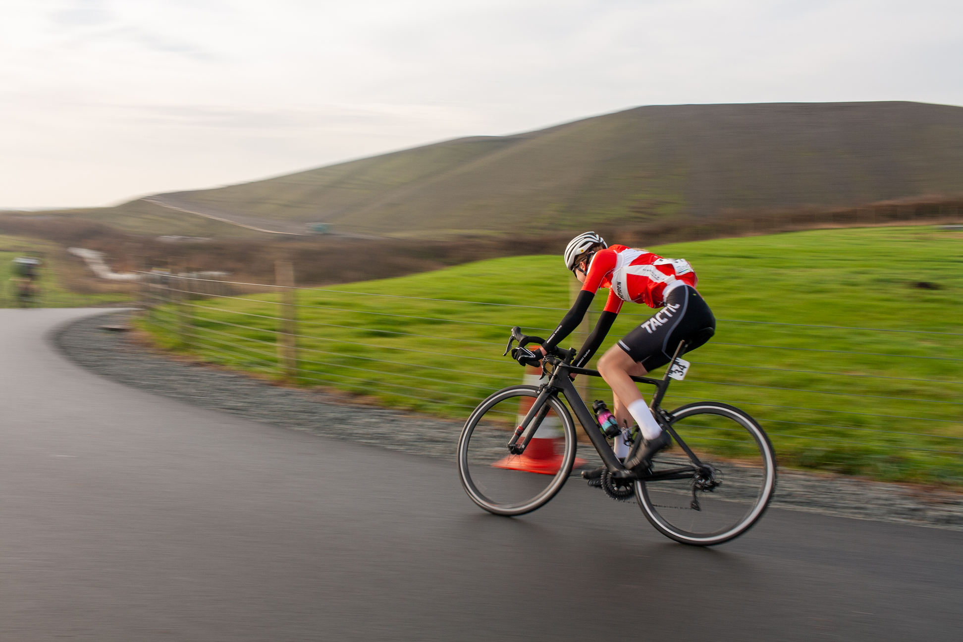 A person wearing a red shirt and black shorts rides a bike.