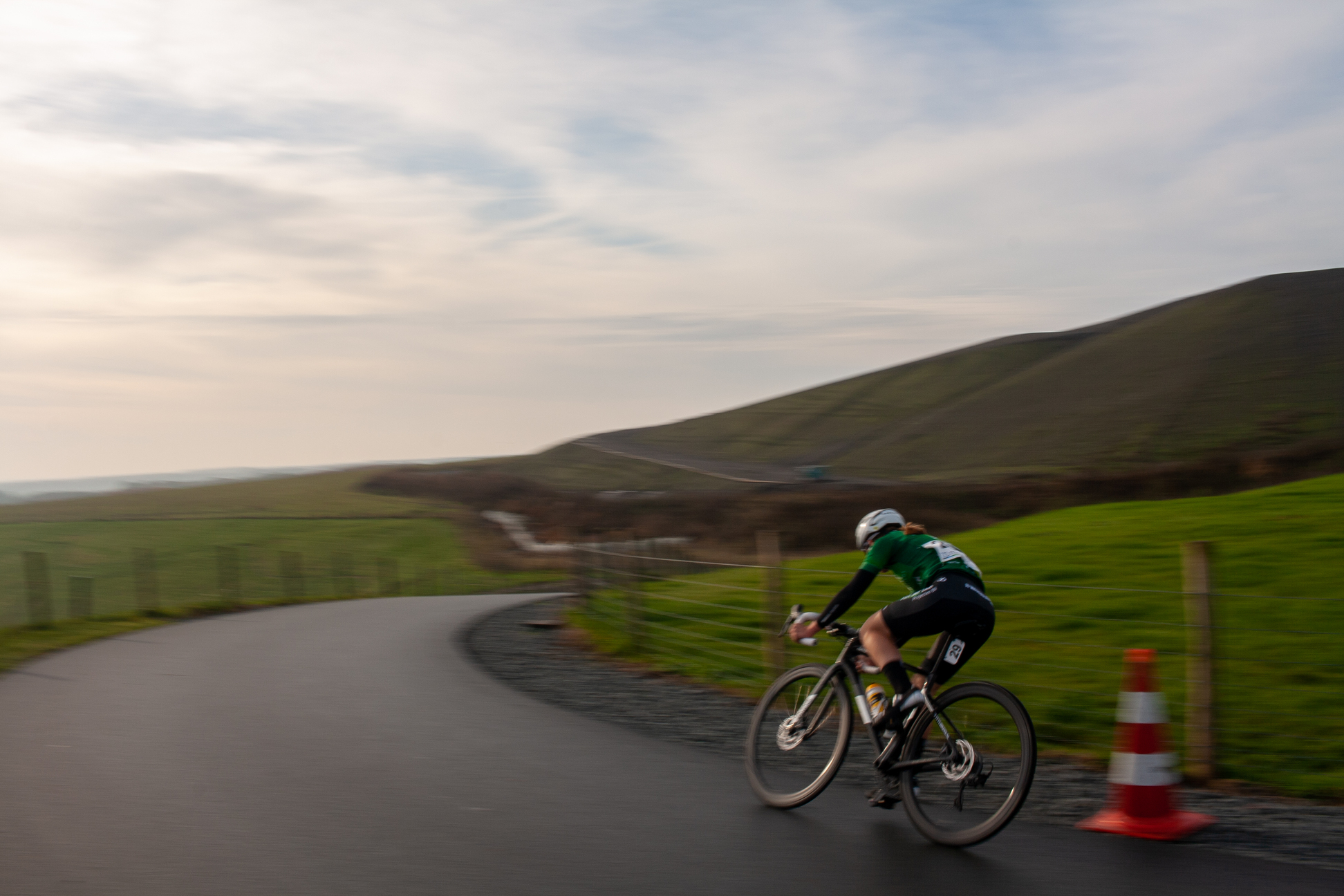 A person on a bike wearing number 8 and riding down a curvy road.