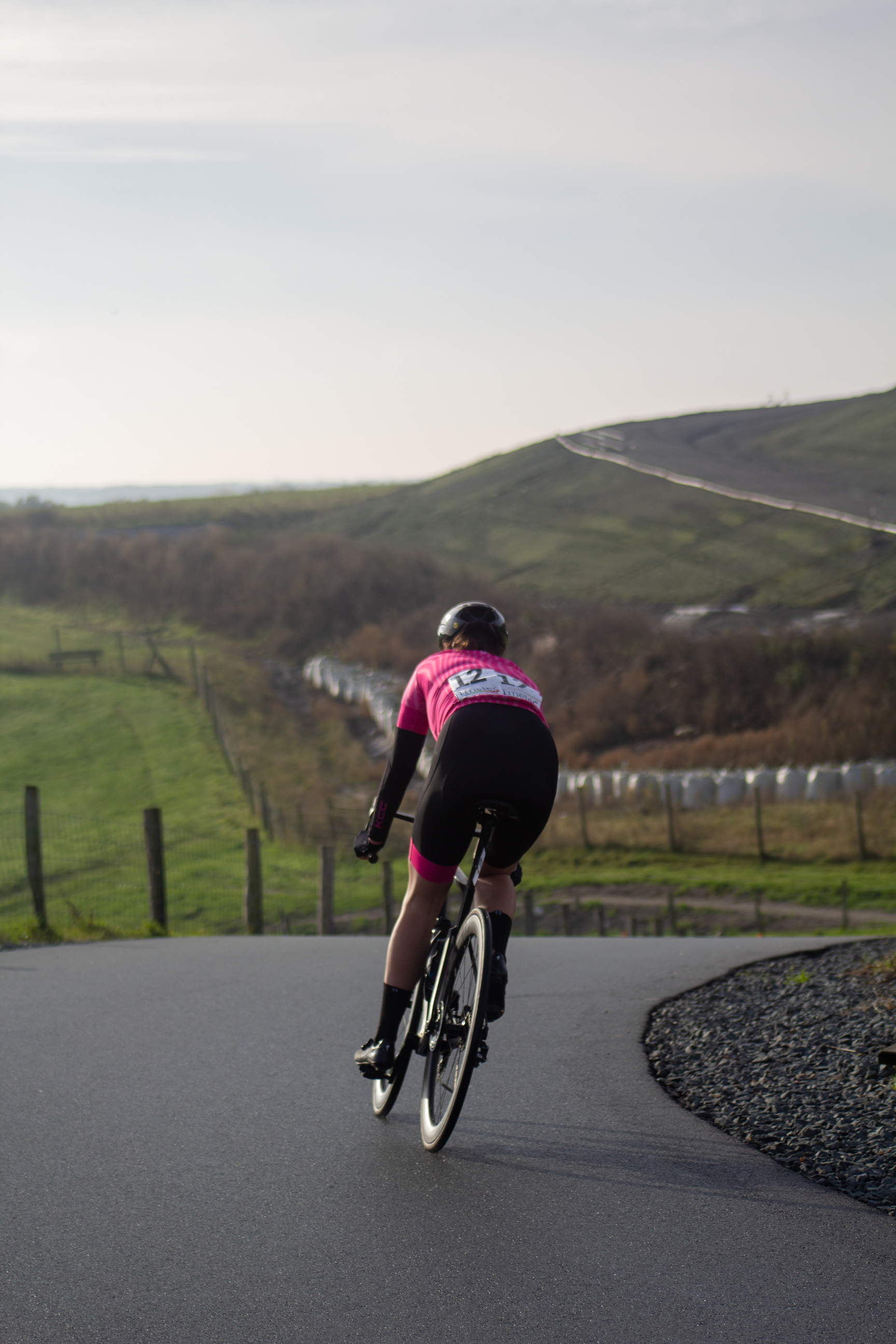 A man on a bicycle with an NK sticker on his back.