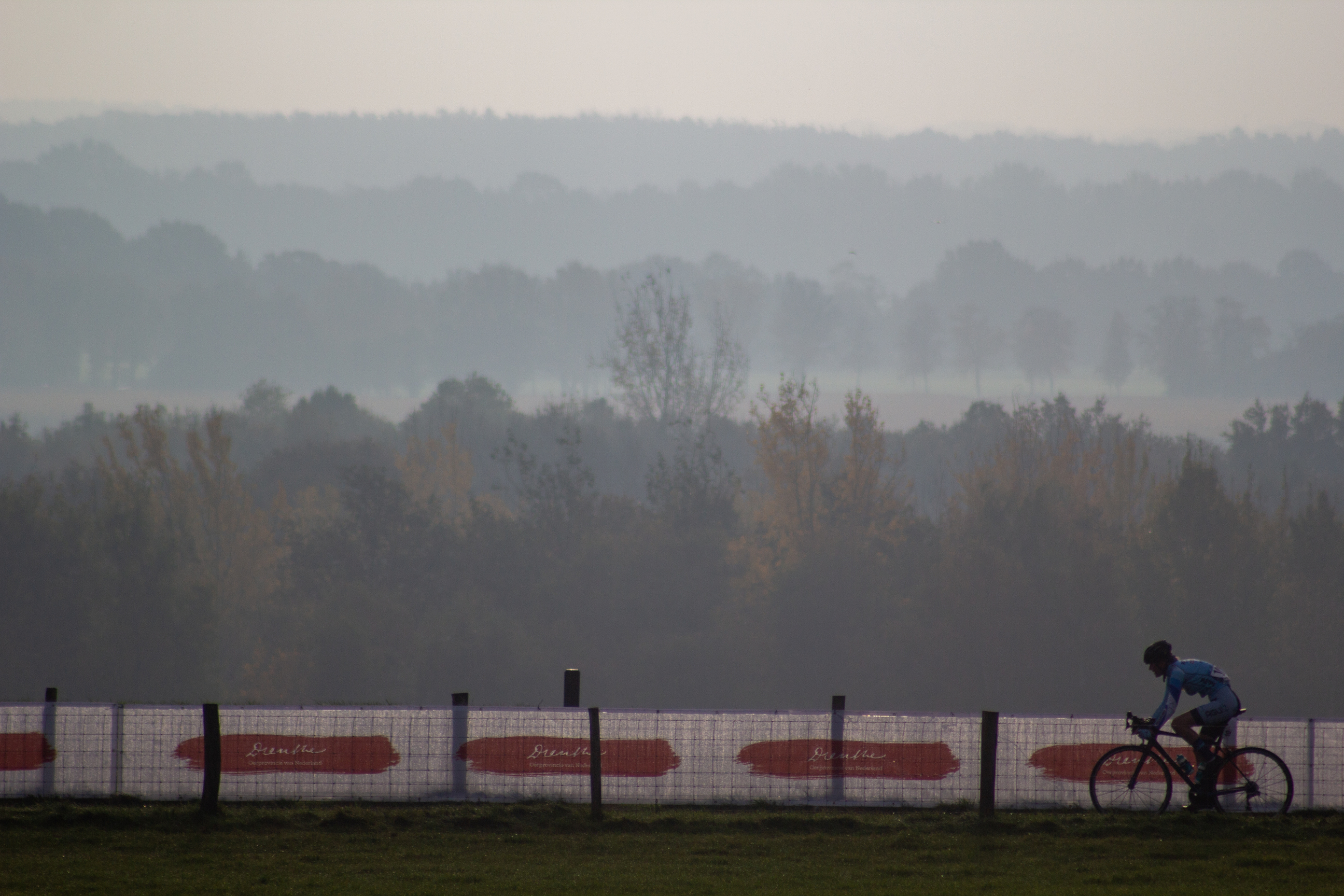 A person riding a bike across the NK Nieuweling Dames race track.