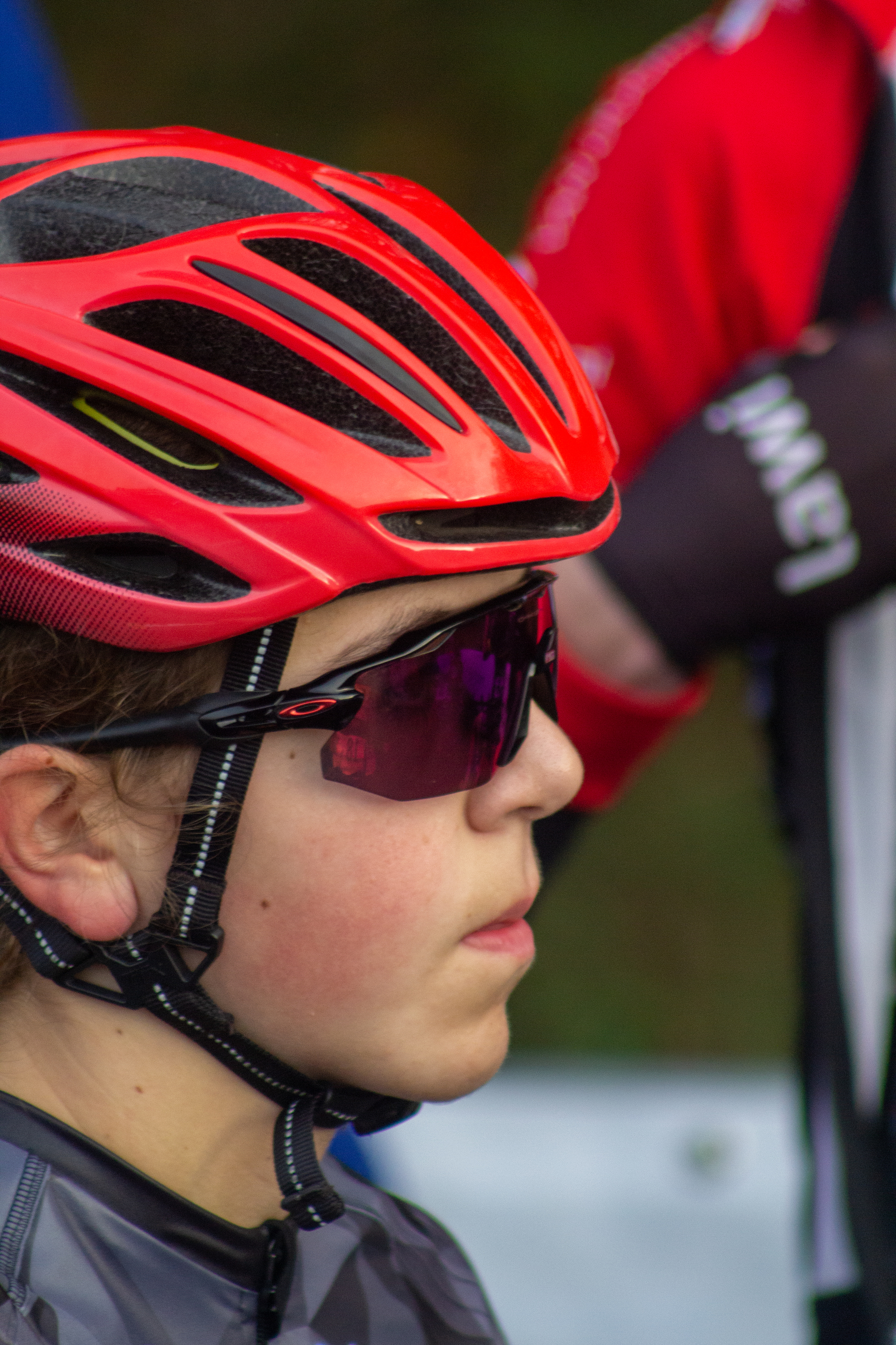 A person wearing a red helmet and black sunglasses.