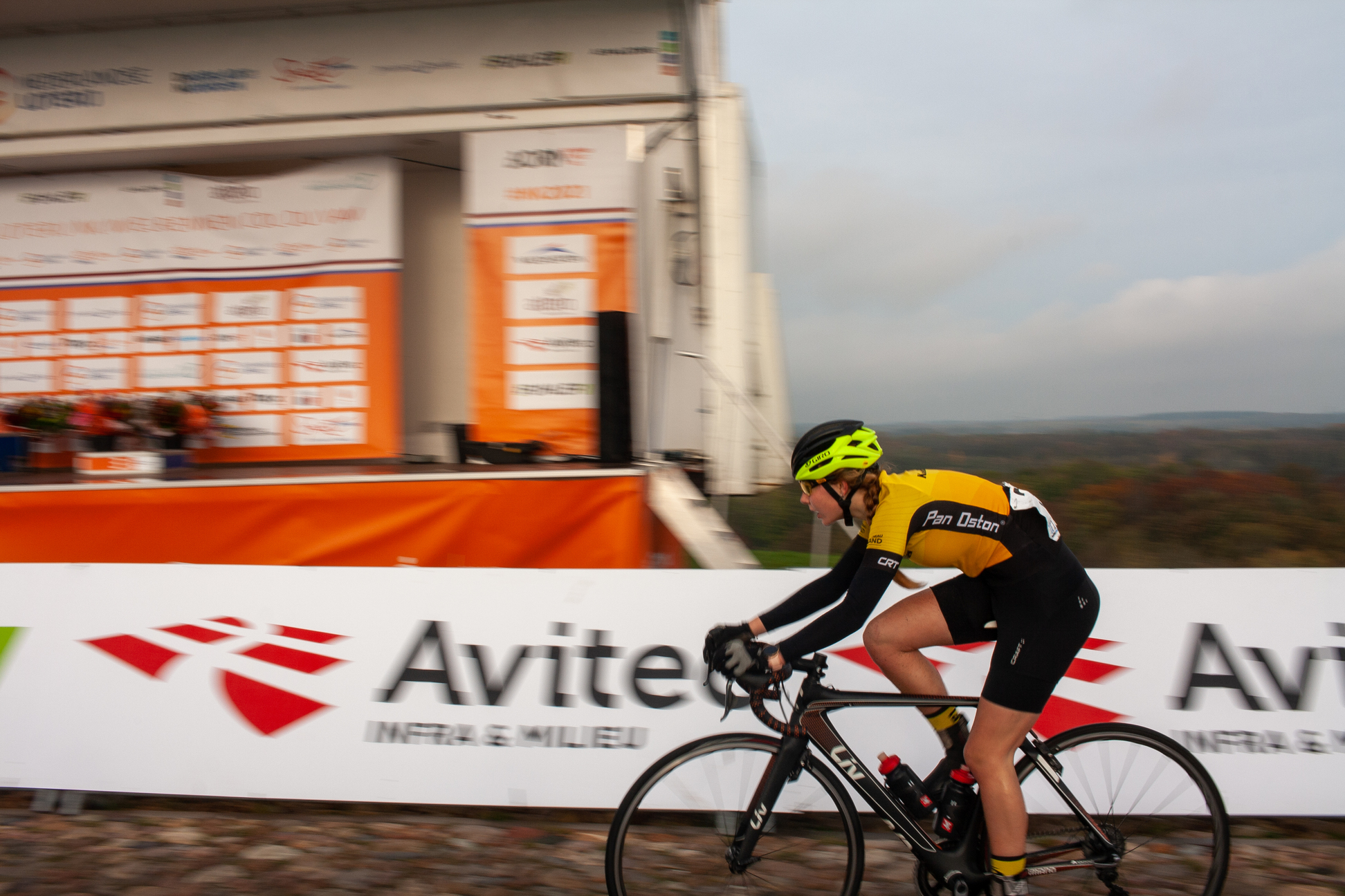 A person wearing a yellow and black jersey is riding a bicycle.