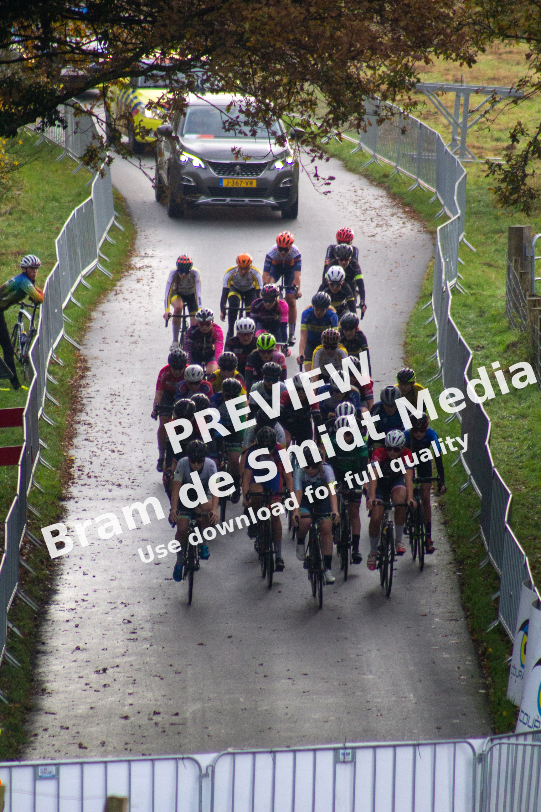A group of bicyclists race down a street in NK Nieuweling dames.