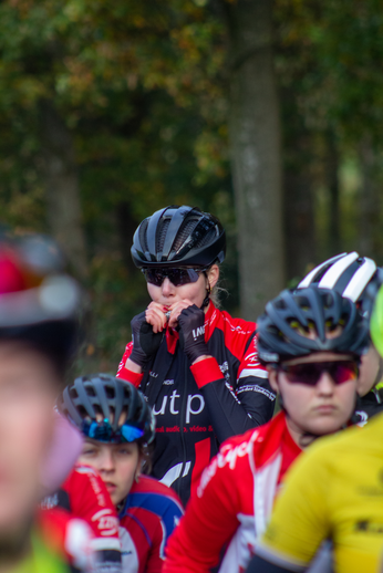 A group of cyclists wearing red and yellow shirts are riding in a race.