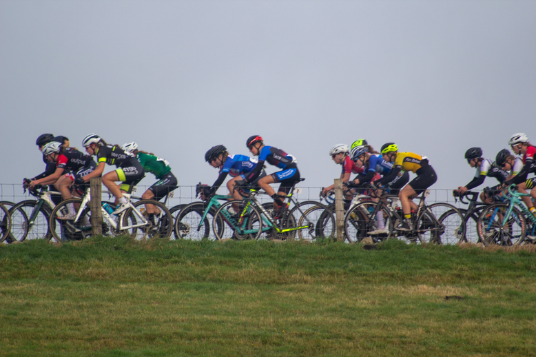 A group of cyclists participating in a race, sponsored by NK Nieuweling.