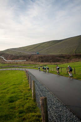 A group of cyclists racing on a paved road. The lead cyclist is wearing a number 24.