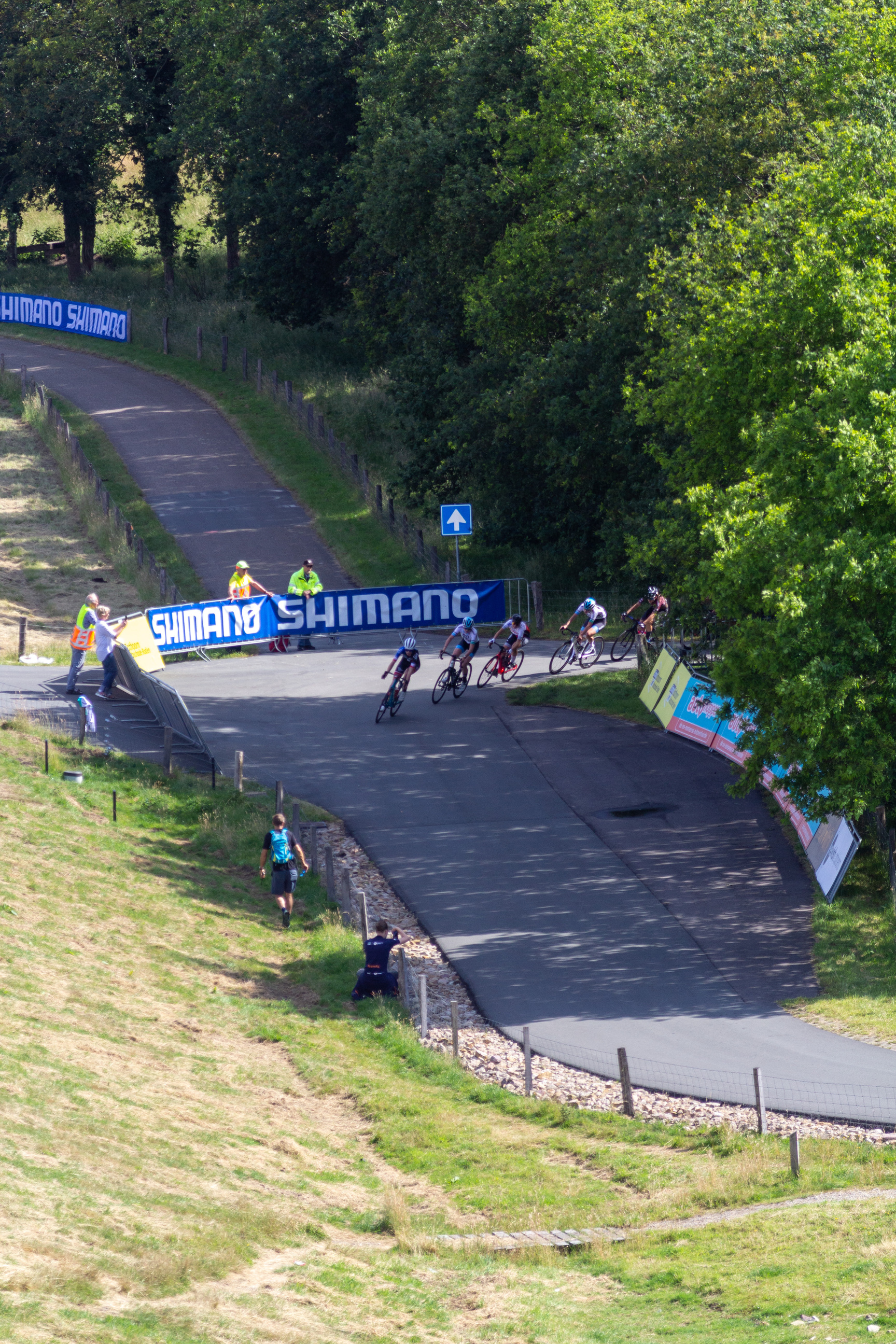 A blue banner that says "Nieuwelingen Dames" is above a road where people are riding bikes.