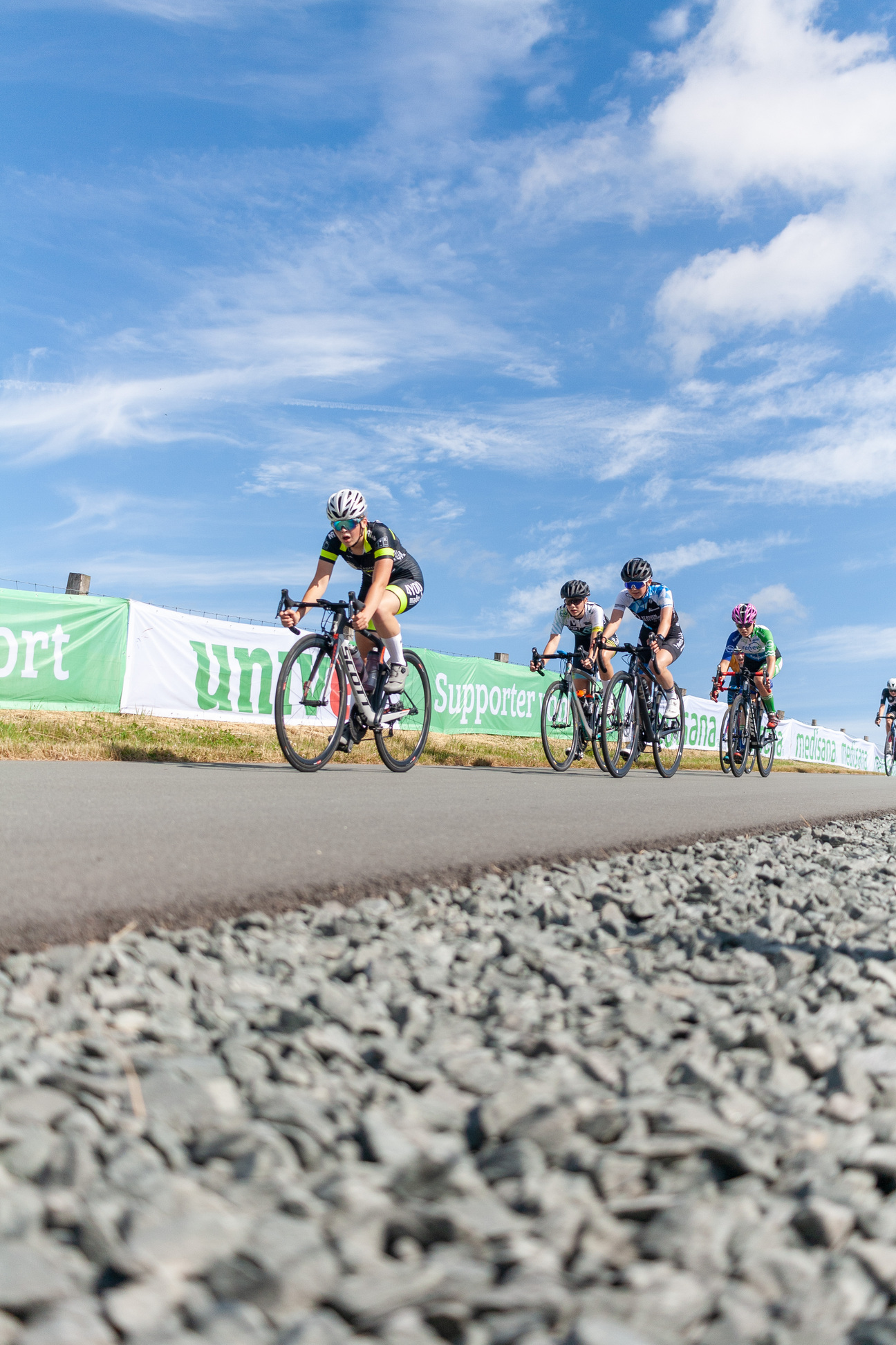 The cyclists are racing down the road in a tourney.