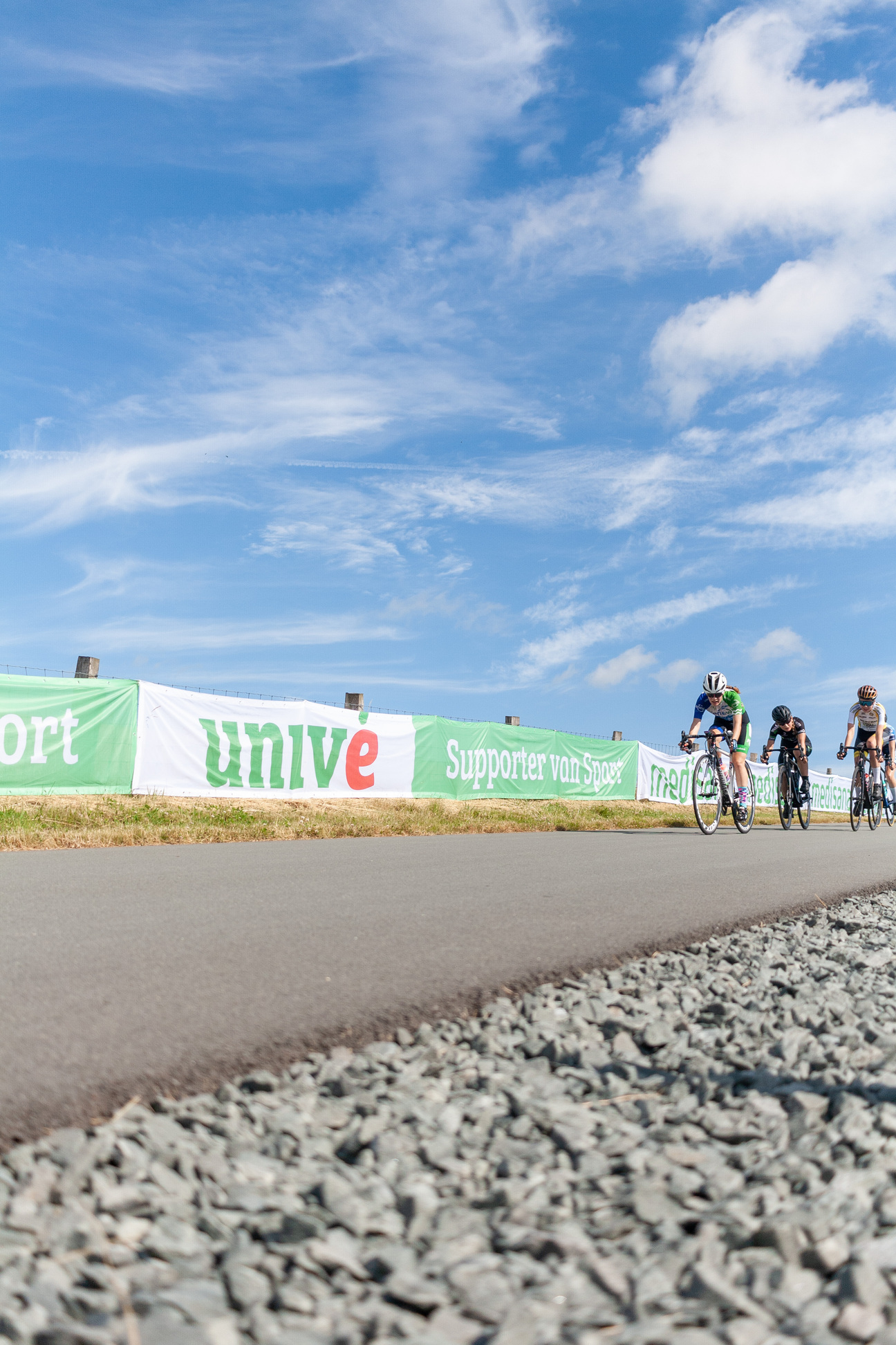 A bike race is taking place on a track with sponsor banners on the walls.