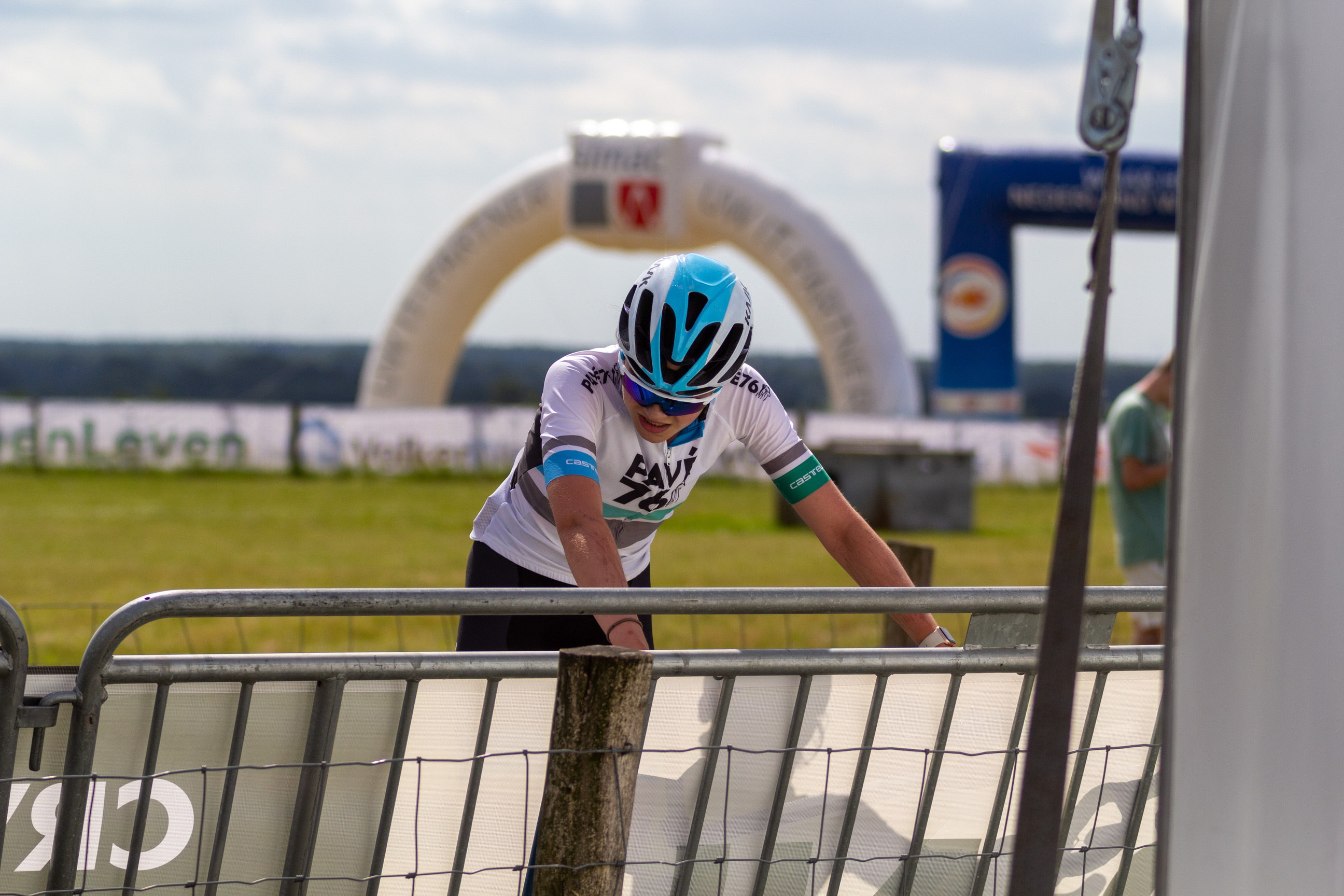 A cyclist at a race track sponsored by Giant Energy.