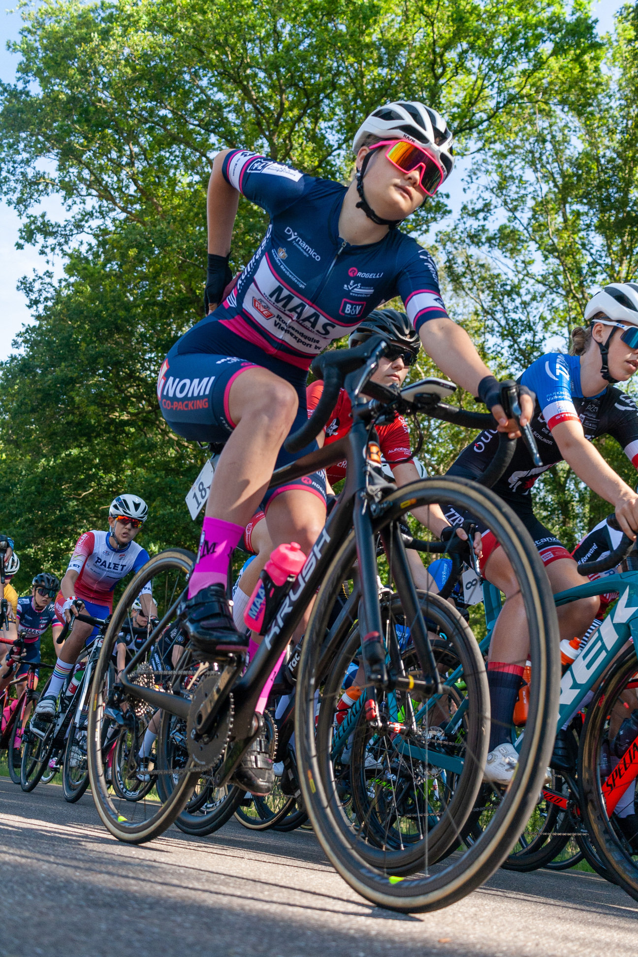 A group of cyclists are wearing jerseys from NK Dames.