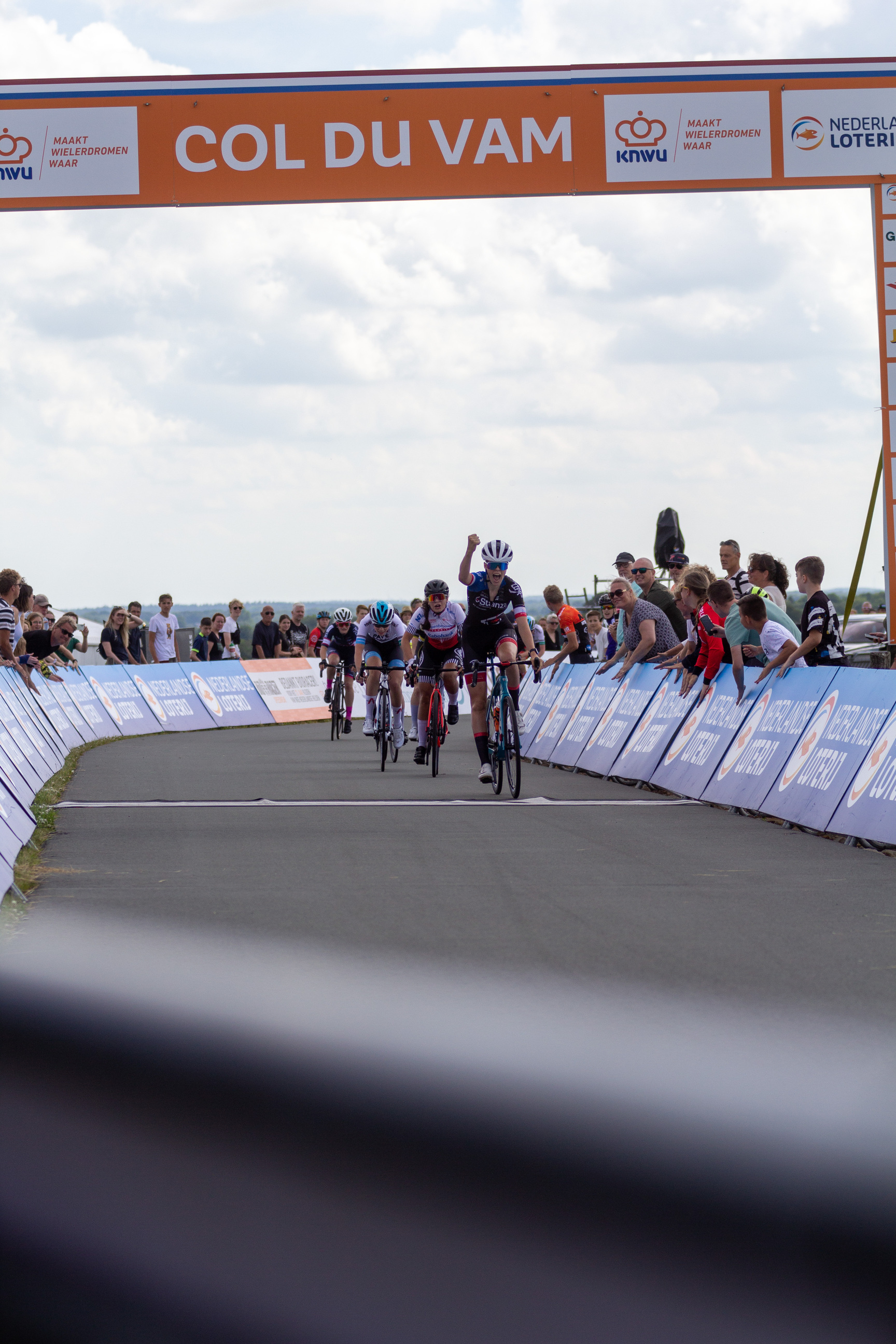 A group of cyclists race to a finish line during the 2022 Wielrennen event.