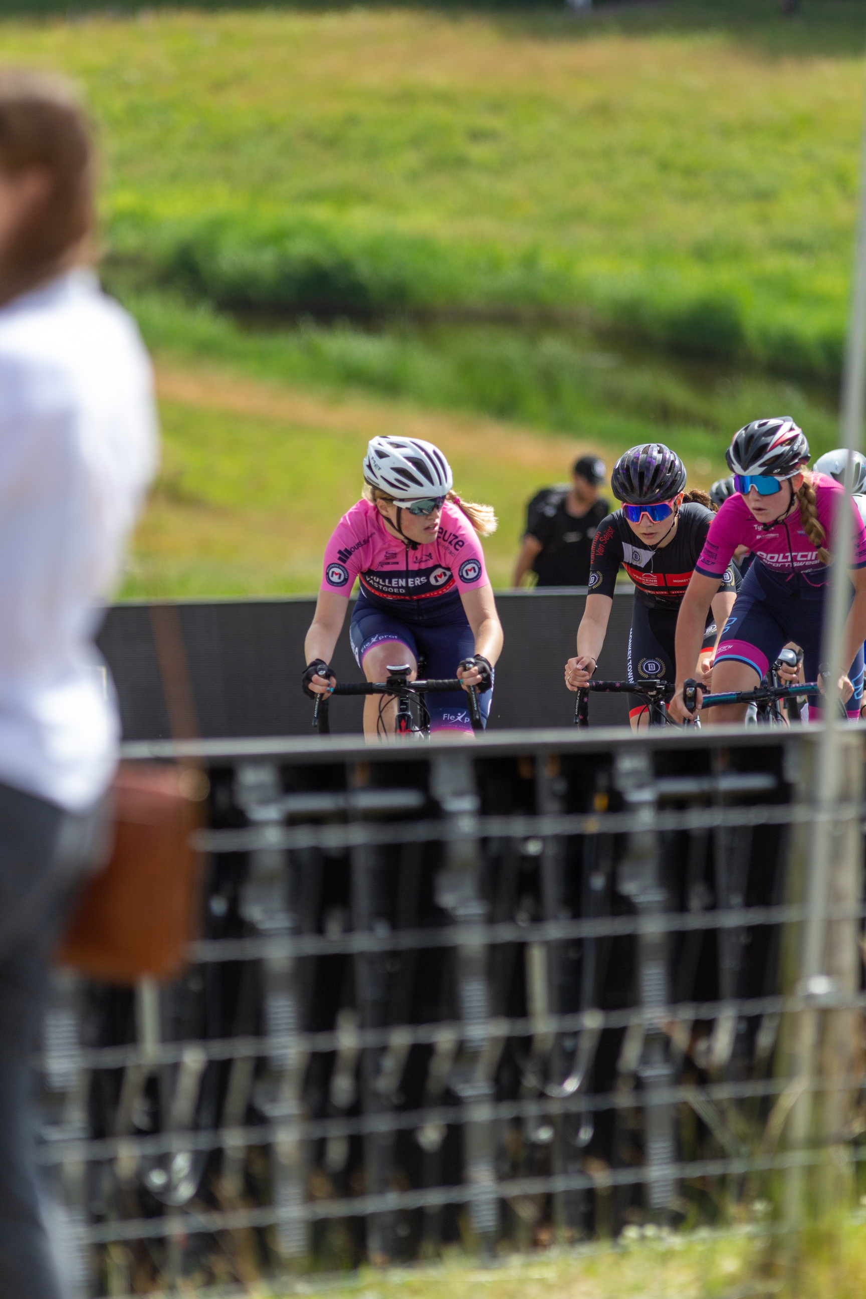 Three cyclists are wearing helmets and racing together.