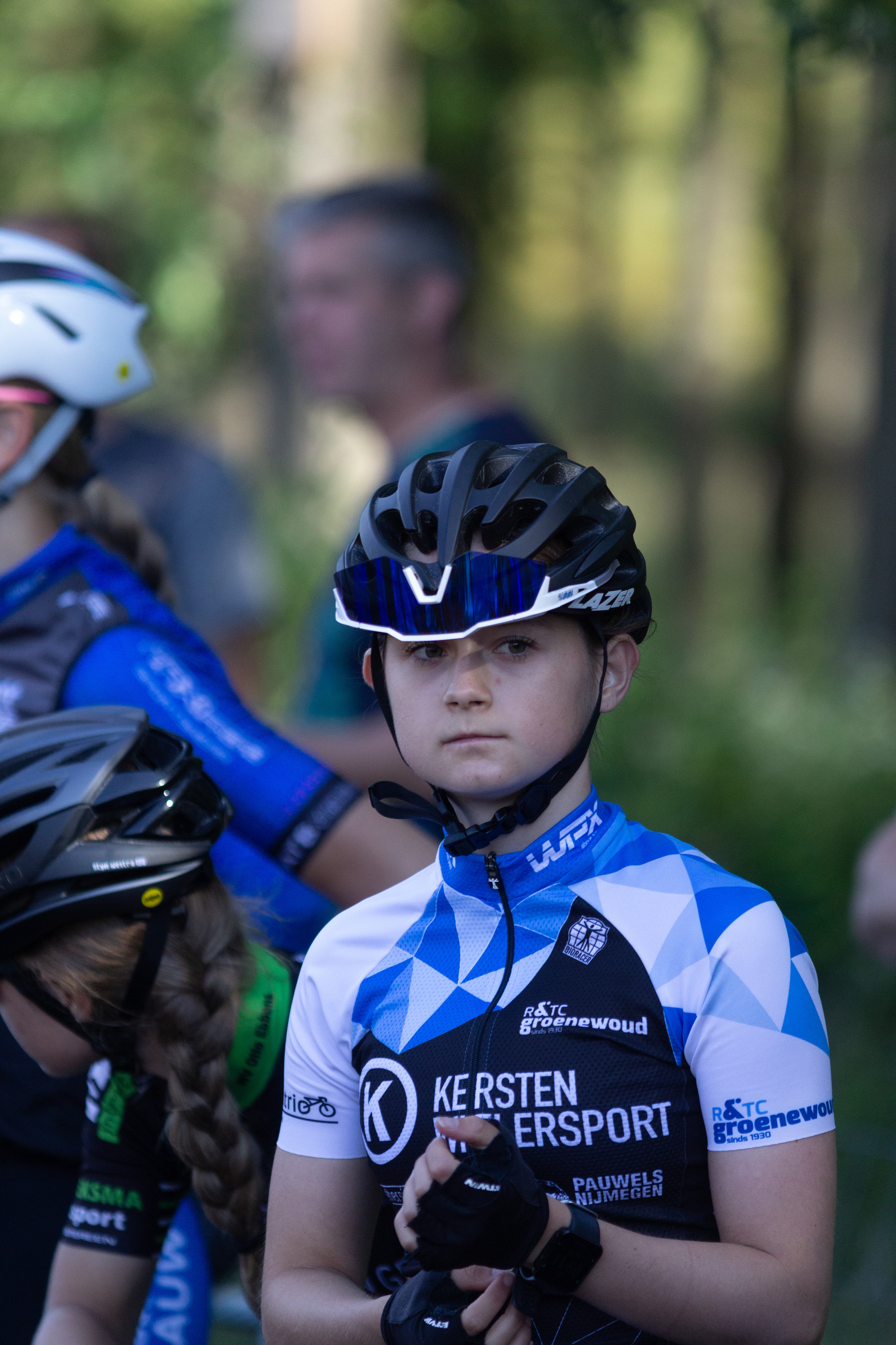 A young girl is wearing a blue and white bike racing uniform.