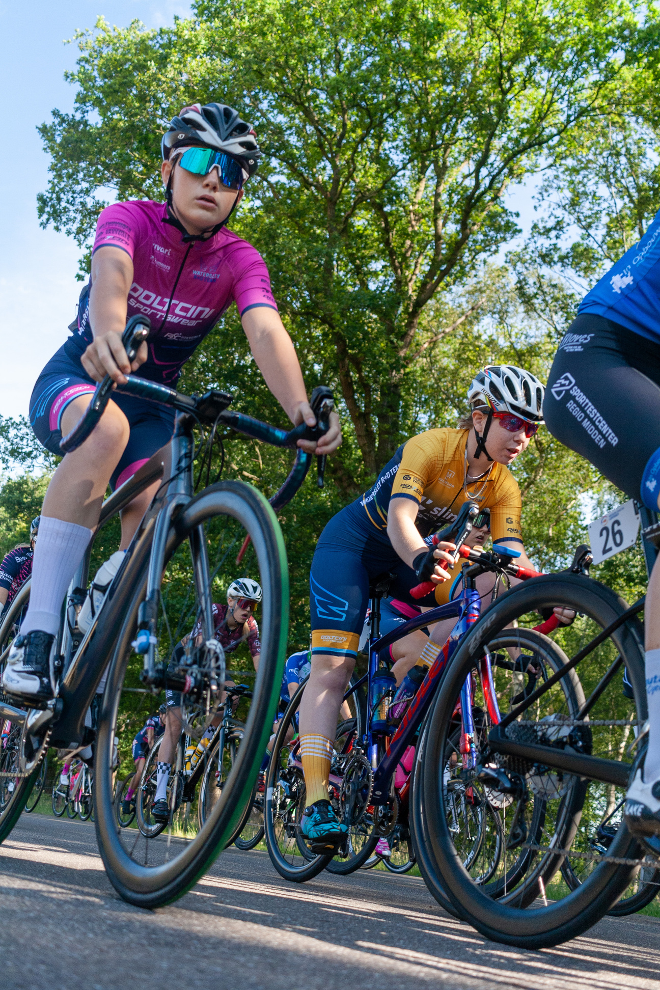 A group of cyclists wearing blue and pink uniforms.