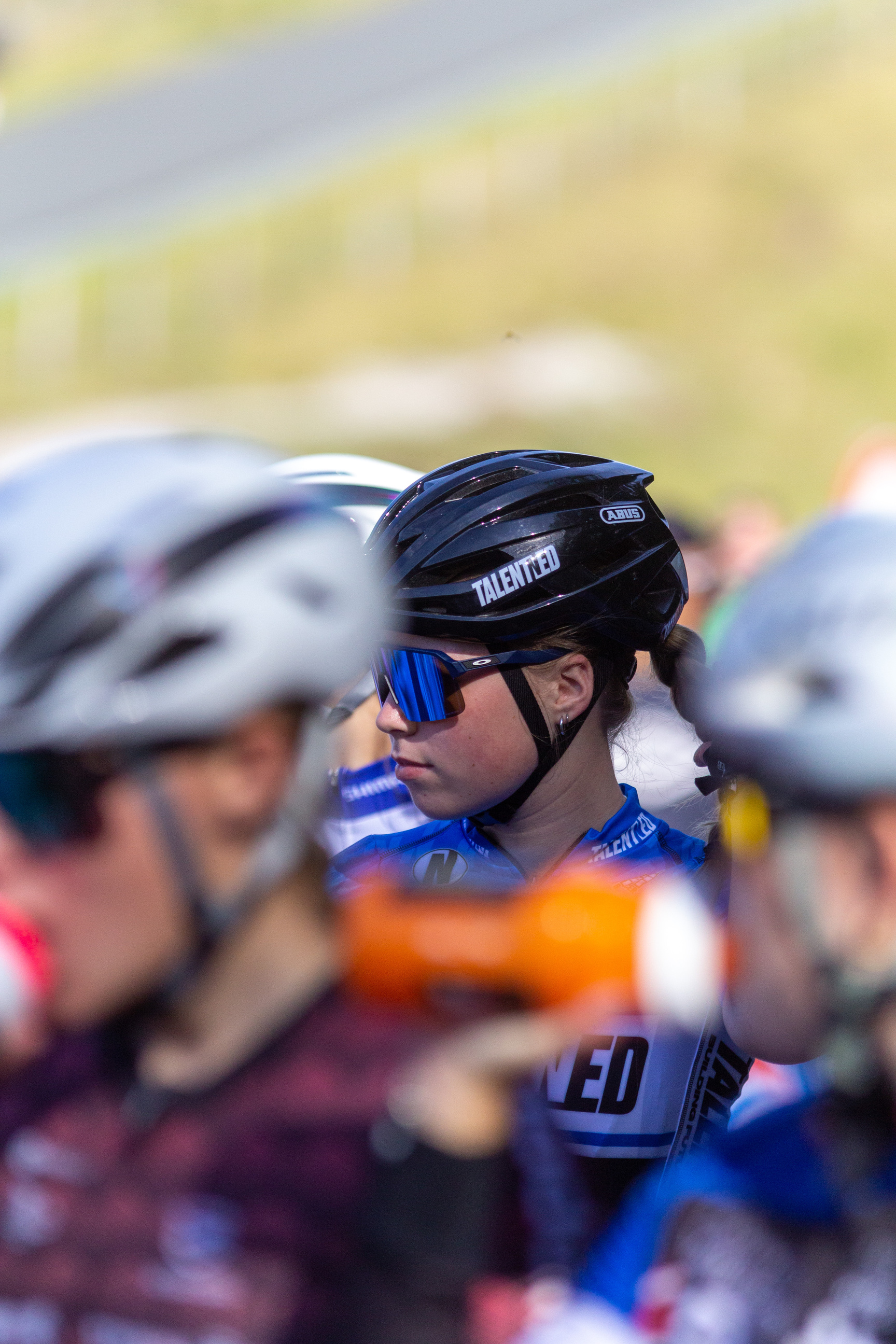 A young woman is wearing a black cycling helmet with a "Giro" logo on the side.