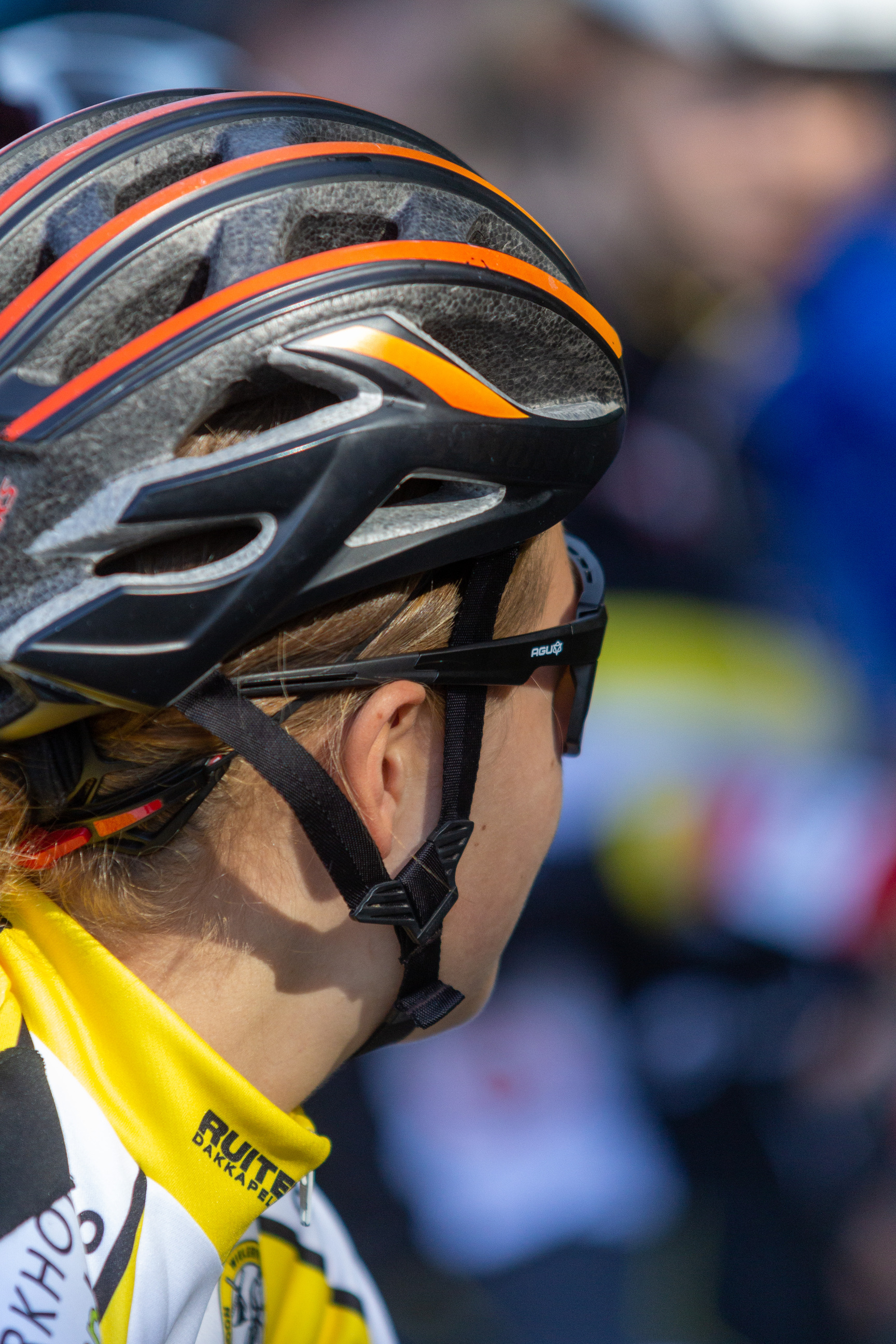 Person wearing a helmet and sunglasses riding a bike.