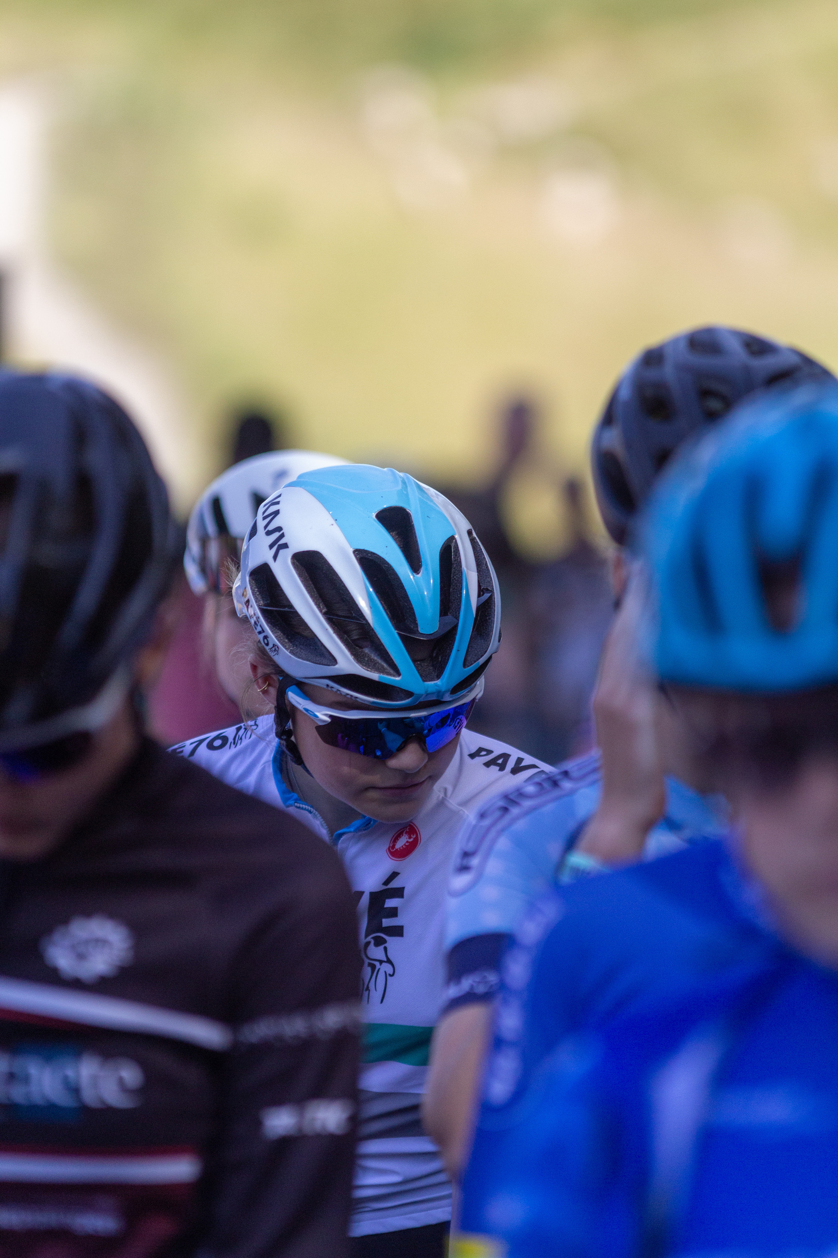 A group of cyclists wear helmets and blue jerseys, sponsored by Giant.