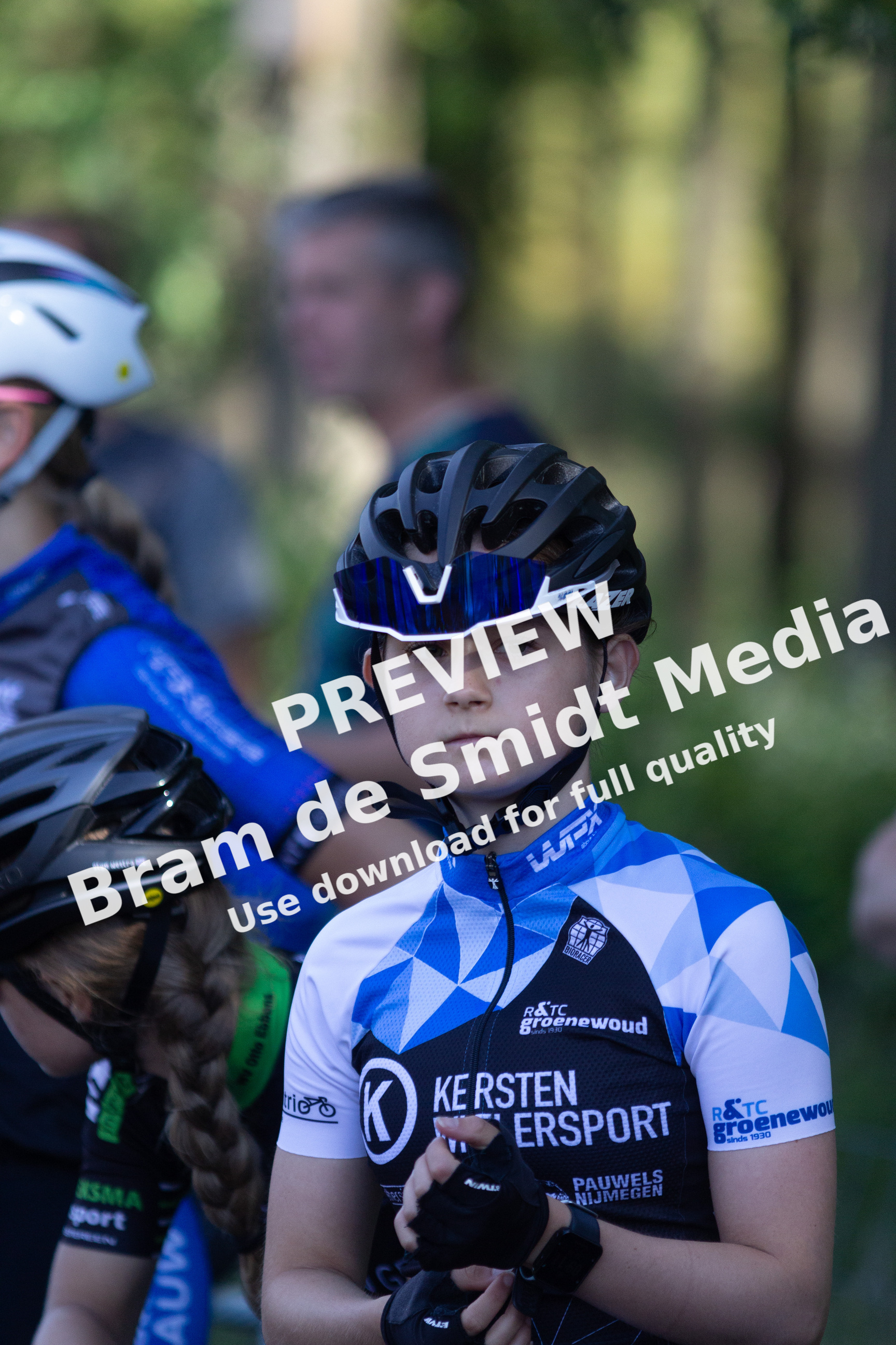 A young girl is wearing a blue and white bike racing uniform.