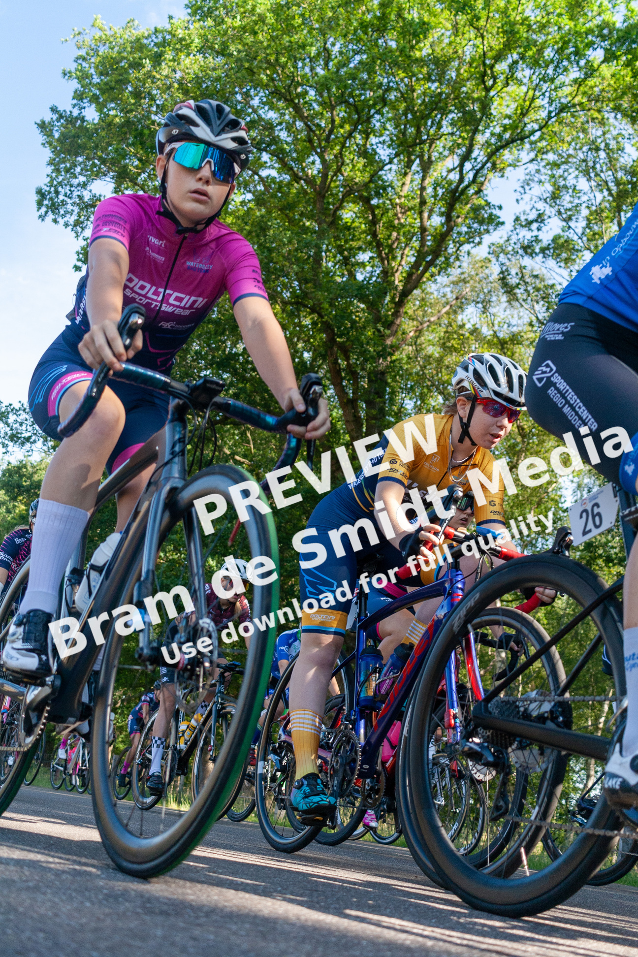 A group of cyclists wearing blue and pink uniforms.