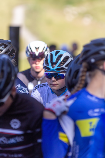 A group of cyclists wearing helmets with blue and white colors.