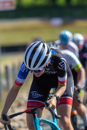 Women riding bikes in a race wearing Zipp jerseys and helmets.