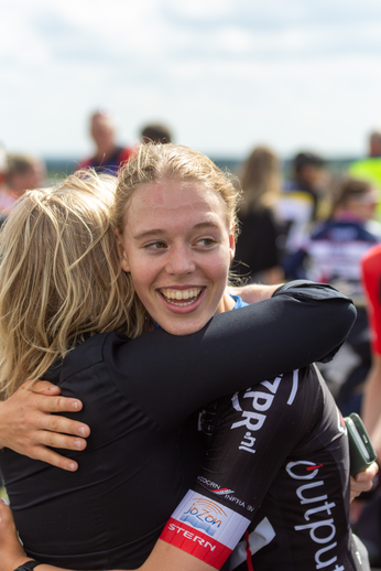 Two girls hug each other with one wearing a shirt that says "Sprint".