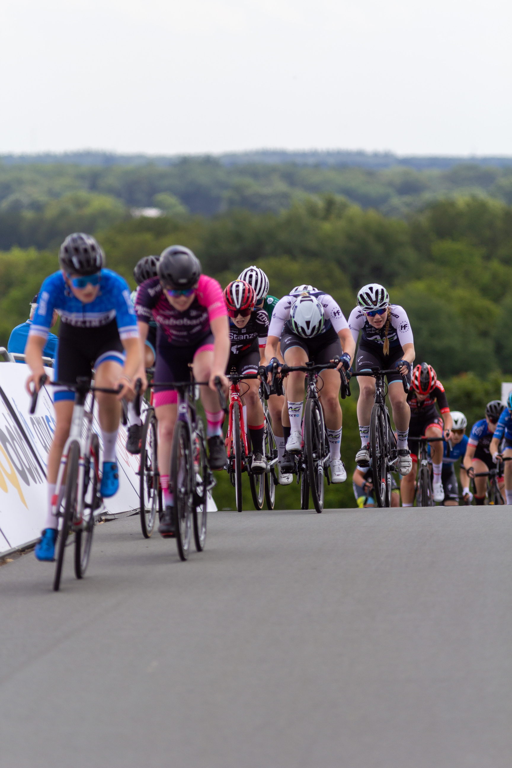 A group of cyclists in a race, one of whom is wearing a jersey with the word "Junioren".