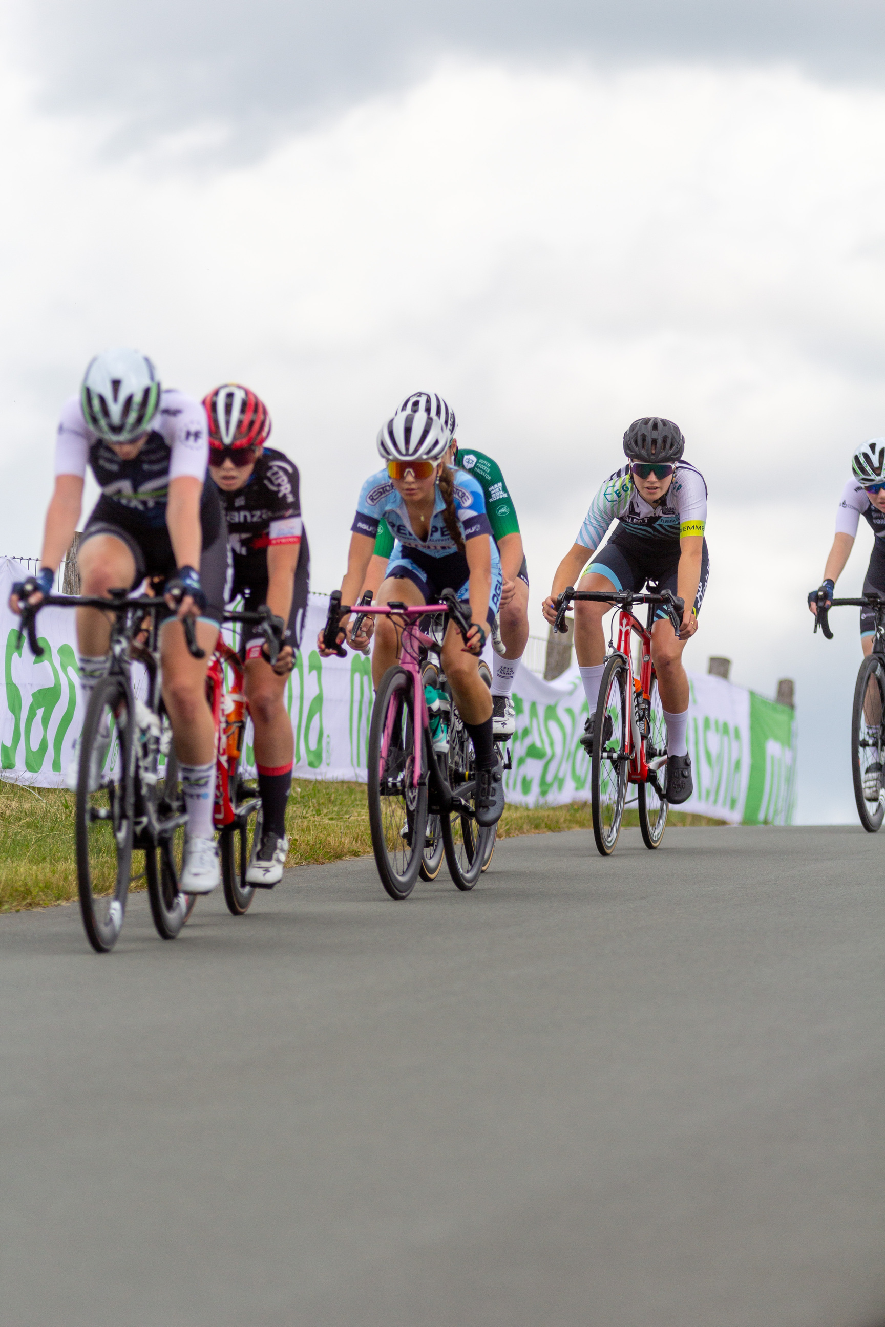 A team of cyclists racing on a road with the words "Junioren Dames" visible.