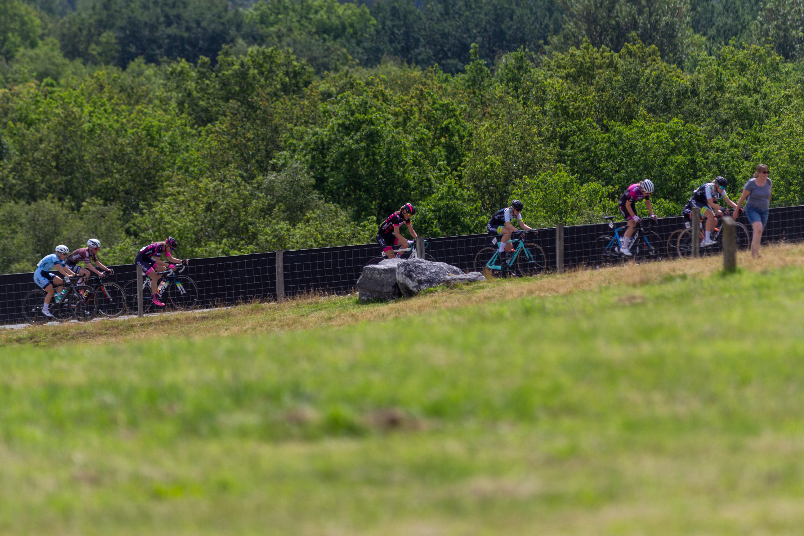 A group of cyclists riding on a hill, 5 people are wearing number 2.