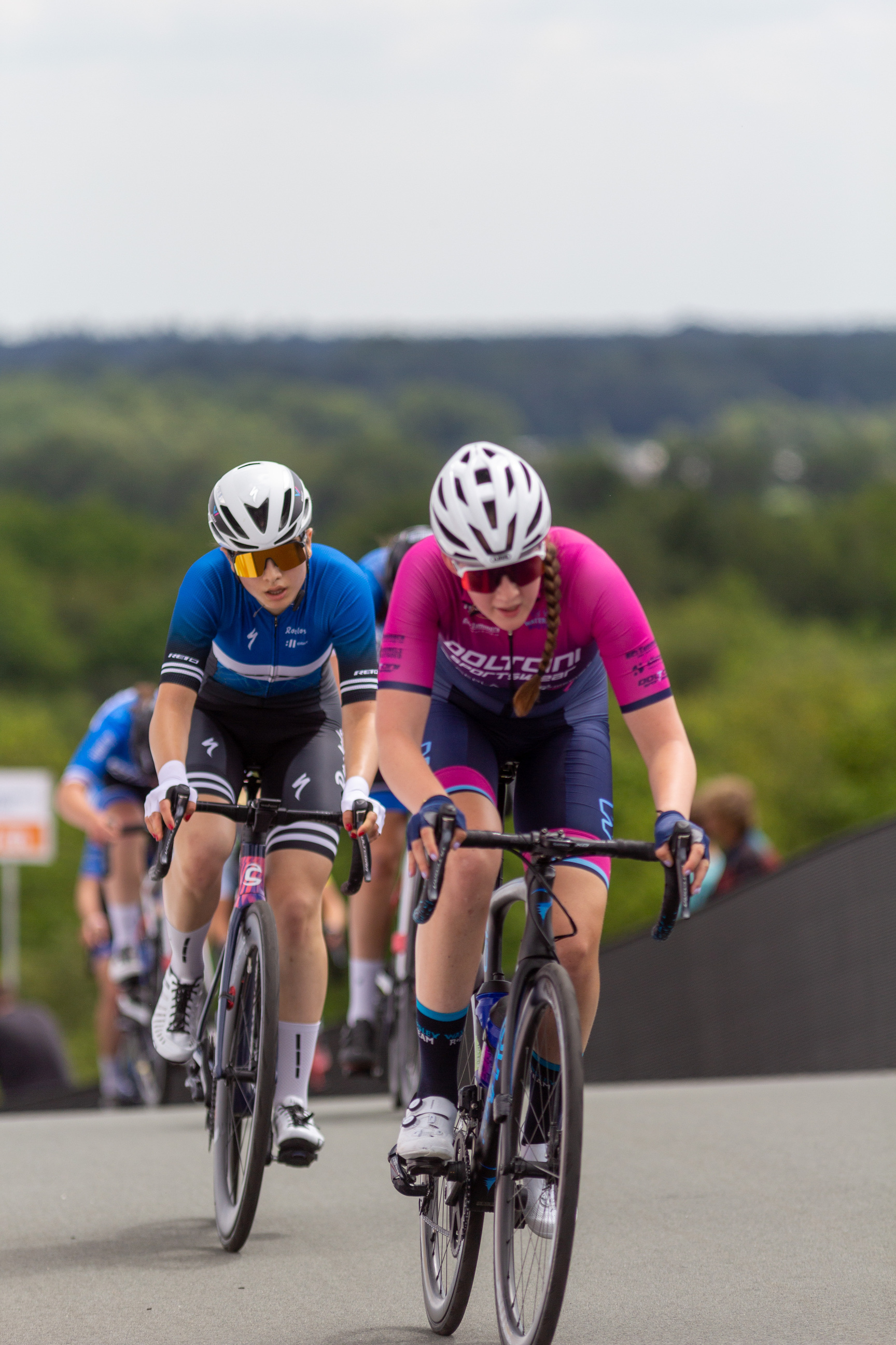 Two cyclists are wearing a number 6 on their shirts.