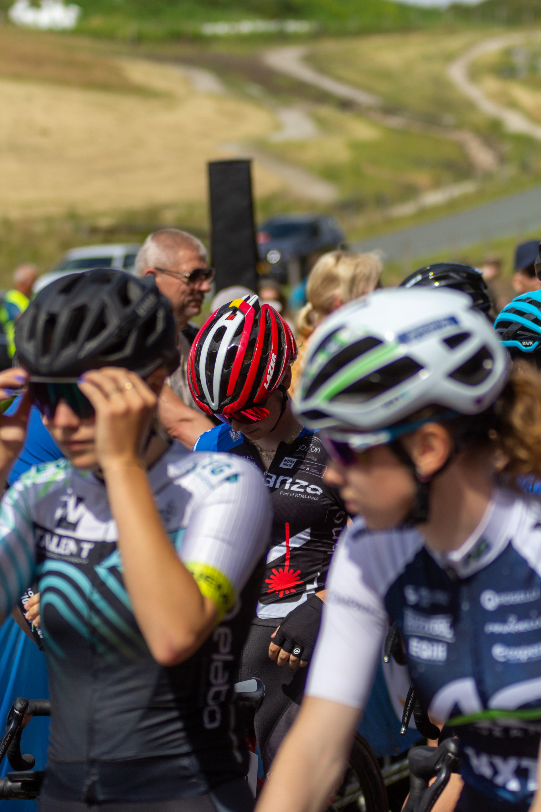 A group of cyclists wearing helmets and blue jerseys with the letter N on them.