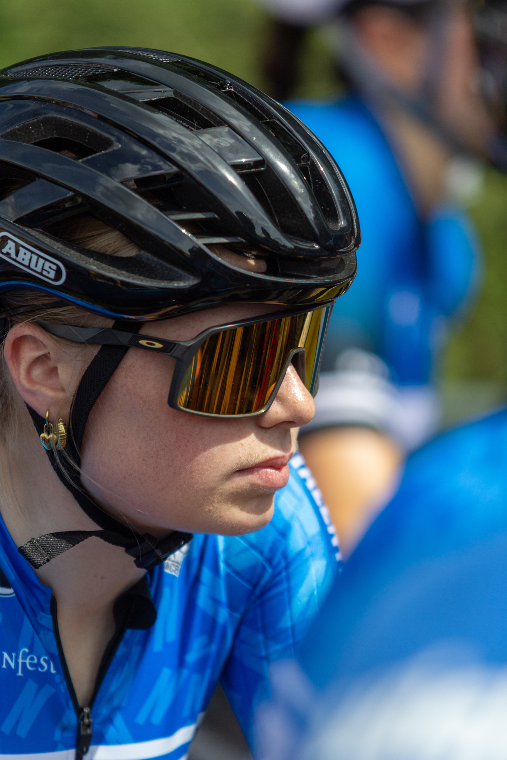 A woman wearing sunglasses in a blue and white jersey for NK Dames.