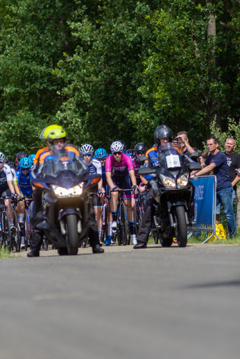 Junioren Dames race 2022 with cyclists wearing helmets and racing.