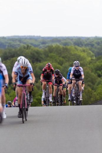 A group of female cyclists in a race sponsored by Dames.