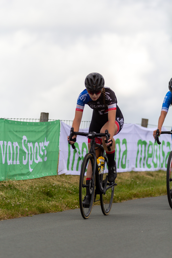 Two people are riding bikes with the word "Junioren" on their shirts.