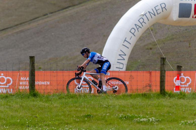 A man riding a bicycle on the grass with the words "Partner" hanging above him.