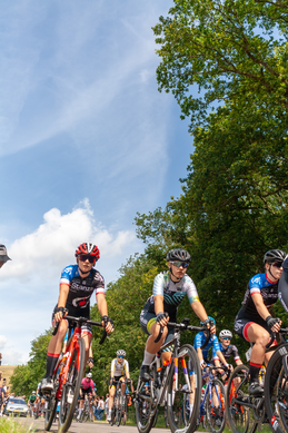 A group of cyclists in a race with one wearing the number 4 on her jersey.