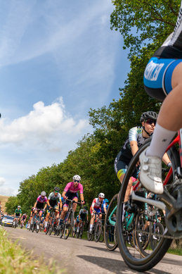 A picture of a person racing their bike on a road.