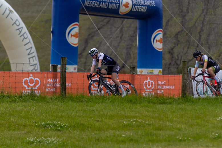 A man is on his bike at a competition. He has the number 1 and is wearing a blue shirt.